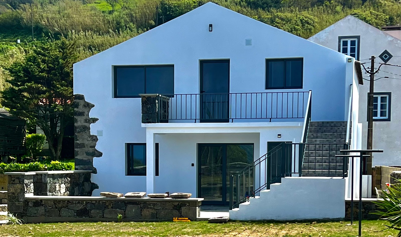 Casa dos Camisas exterior with green hills and ocean views